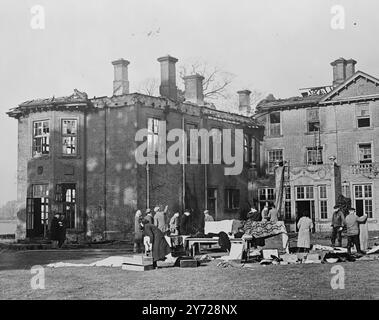 Naseby Hall eviscerato dal fuoco. La storica Naseby Hall, Northants, sulla scena della battaglia Roundhead and Cavalier del 1645, e la scatola da caccia del re e della regina del 1928 è stata praticamente distrutta da un incendio oggi (giovedì). Il colonnello R.L. Findlay e sua moglie, che hanno perso tutto nel fuoco, hanno usato lenzuola e coperte unite insieme per fuggire dalla loro camera da letto in fiamme. Furono svegliati da servi ucraini che lanciavano pietre alla loro finestra. Tutte le 33 camere della sala sono state rovinate. Illustrazioni: I mobili recuperati sono collocati all'esterno della sala eviscerata dopo l'incendio di oggi a Naseby. 12 febbraio Foto Stock