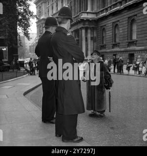 Gatecrasher - stile Grand Dame. Londra; agenti di polizia londinesi in servizio a Downing Street questo pomeriggio, nana e una vecchia signora non identificata che si è messa a letto nella sua raffinatezza e che si chiedeva se potesse chiamare al numero 10 per una bella tazza di tè e una chiacchierata con la signora Mary Wilson , moglie del primo ministro laburista britannico . Nel frattempo , la signora Wilson stava intrattenendo le mogli dei Commonwealth Premiers in visita al tè nella sua casa ufficiale a Londra per la loro conferenza annuale che si è aperta alla Marlborough House . Evidentemente, la piccola signora anziana immaginava che ci fosse stata una svista su Foto Stock