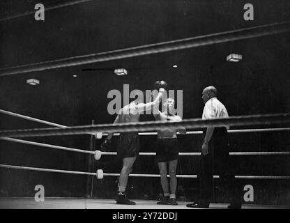 Mills sulla strada di ritorno. Il campione britannico dei pesi mediomassimi Freddie Mills ha sconfitto il belga Pol Goffaux per sottomissione nel quarto round della lotta per il titolo europeo ad Harringay Tonight (lunedì). Dopo aver preso cinque conteggi nel quarto round, la fine belga della lotta salendo a nove, passando il pronto a Mills e alzando la mano del Britisher nella vittoria. Mills inizia a ristabilirsi nei circoli di boxe dopo la sua schiacciante sconfitta per mano di Lloyd Marshall. Spettacoli fotografici, Goffaux (fotocamera frontale) anticipa l'arbitro tenendo la mano di Freddie Mills Foto Stock