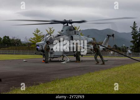 US Marines con Marine Light Attack Helicopter Squadron 367, Marine Aircraft Group 36, 1st Marine Aircraft Wing si preparano a rifornire un AH-1Z Viper hel Foto Stock