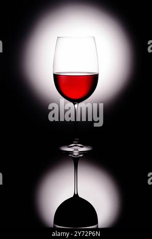 Grande vino rosso di vetro a forma scura da uva bevanda alcolica su sfondo luminoso Foto Stock