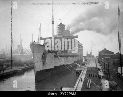 Bacino di carenaggio "Queen Mary" per il completamento della revisione. Questa mattina presto (sabato). La Cunard White Star Liner Queen Mary, veterano di migliaia di chilometri, quindi in tutto il mondo come nave truppe durante la guerra, fu allevata nel King George V Graving Dock a Southampton, per subire la seconda fase della sua riconversione in linea di lusso. È stata messa a riposo lo scorso settembre, quando sono state rimosse le attrezzature speciali per le truppe e gli accessori usurati. I prossimi due mesi vedranno molte modifiche e ristrutturazioni del suo scafo e della sua struttura in preparazione al rientro delle grandi navi nel servi passeggeri dell'Atlantico settentrionale Foto Stock