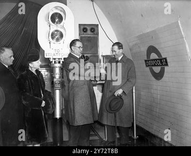 La RT. A.J. Barnes, Ministro dei trasporti, dichiarò aperta la prima sezione dell'estensione orientale della Central London Railway da Liverpool Street a Stratford. L'estensione è il primo collegamento in uno dei più importanti progetti di trasporto di Londra - in definitiva il servizio sarà esteso a Loughton, Essex, Newbury Park e Ongar. I tunnel per l'estensione, per un totale di 8 1/4 miglia di lunghezza, furono guidati prima della guerra e durante le ostilità, usati come rifugio. L'immagine mostra: La chiave d'oro che il Ministro dei trasporti (a destra) ha usato per aprire il sistema di segnalamento per inaugurare una nuova e Foto Stock