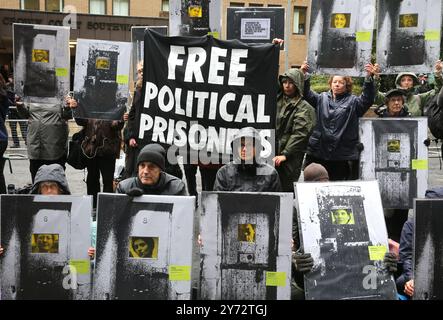 Londra, Inghilterra, Regno Unito. 27 settembre 2024. I manifestanti tengono uno striscione che dice "prigionieri politici liberi” al di fuori del tribunale. Un gruppo di manifestanti tiene dei cartelli fuori dal Southwark Crown Court a Londra, sottolineando il fatto che, su istruzione dei giudici, molti attivisti incarcerati non sono stati in grado di spiegare appieno il motivo per cui hanno intrapreso l'azione che hanno fatto. (Credit Image: © Martin Pope/ZUMA Press Wire) SOLO PER USO EDITORIALE! Non per USO commerciale! Foto Stock