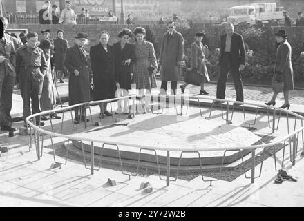 A Coventry è stata inaugurata una pietra incisa con la simbolica Fenice che sorge dalle ceneri, per segnare il centro della nuova città che sarà costruita dove i bombardieri Hitler hanno piovuto distruzione nel raid "Baedeker" del 1940. Conosciuta come la pietra livellante, è posta sul sito della casa dove nacque Dame Ellen Terry nel 1847. Sotto di esso ci sono una serie di documenti che saranno ispezionati tra 100 anni. L'immagine mostra i turisti che visitano la Levelling Stone in Stafford Street, Coventry. 6 novembre 1946 Foto Stock