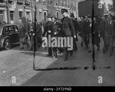 Un uomo e' stato arrestato fuori dall'hotel Ivanhoe, Bloomsbury, ed e' stato scortato alla stazione di polizia di Tottenham Court Road stamattina. L'hotel Ivanhoe e' stato preso da "squatters" ieri sera. Immagini: L'uomo arrestato viene portato via dagli agenti di polizia. 11 settembre 1946 Foto Stock