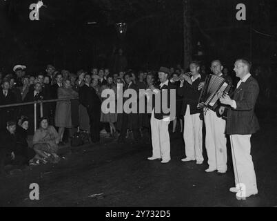 I visitatori della parata della vittoria che si sono recati nella capitale o durante la notte e la mattina presto (sabato) erano ancora in uno stato d'animo molto gay, anche dopo il peso di molte ore. C'erano dei marciapiedi per famiglie comodi per il soggiorno notturno, e c'erano molte forme di intrattenimento. L'immagine mostra la musica mentre aspettano in Trafalgar Square la mattina presto, mostrando quattro musicisti che intrattenono parte della folla. 8 giugno 1946 Foto Stock