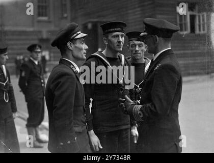 Comando tenente Rupert Philip Lonsdale R.N.commander del sottomarino "Seal" durante il suo ultimo viaggio prima di essere catturato dai tedeschi al largo della Svezia nel maggio 1940, apparve nella stanza verde e color crema della R.N. Barracks a Portsmouth. La foto mostra i marinai del "Seal" fuori dall'aula di tribunale con il capitano G.C. Phillips, R.N., (a destra) ufficiale al comando della HMS "Dolphin", base sottomarina a Portsmouth difeso tenente comandante R.O. Lonsdale. 10 aprile 1946O Foto Stock