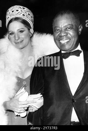 La cantante, l'attrice Barbra Streisand e il co-protagonista Louis Armstrong sono stati accolti da una raffica di cameraman e più di 1.000 fan quando sono arrivati ieri sera per la prima mondiale di Hello, Dolly! . La signorina Streisand è stata derubata e quasi le ha buttato i piedi diverse volte dopo che la sua limousine si era fermata fuori dal Rivoli Theatre di New York . 17 dicembre 1969 Foto Stock