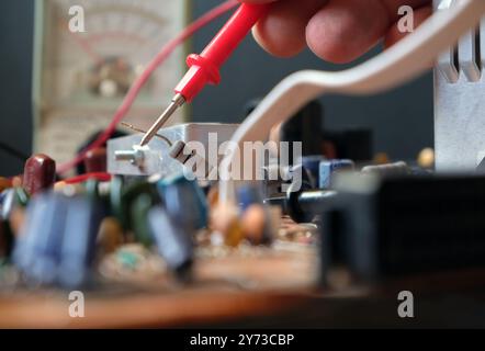 Il tecnico sta eseguendo la ricerca guasti sulla scheda elettronica. Test dei componenti industriali. Focalizzato sul resistore. Foto Stock