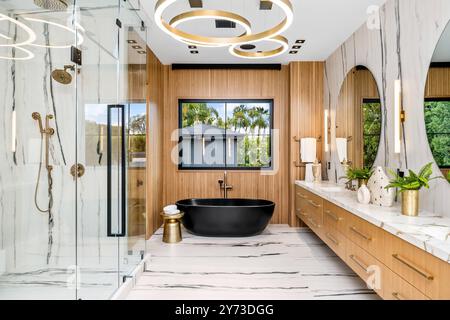 Un bagno moderno e lussuoso con vasca nera e dettagli in legno Foto Stock
