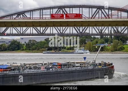 Il ponte Beeckerwerth Reno dell'autostrada A42, traffico di camion, dietro di esso il ponte ferroviario Haus-Knipp, nave da carico sul Reno vicino a Duisburg, Nort Foto Stock