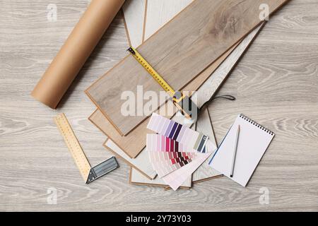 Strumenti, tavolozze di colori, notebook e schede laminate sul pavimento Foto Stock