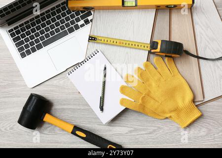 Attrezzi, laptop e schede laminate a pavimento Foto Stock