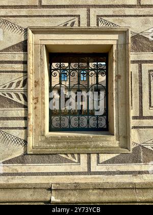 La fotografia cattura una vista dettagliata di un antico cancello medievale in legno e metallo, situato nelle strade di una storica città europea. Foto Stock