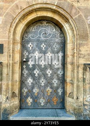 La fotografia cattura una vista dettagliata di un antico cancello medievale in legno e metallo, situato nelle strade di una storica città europea. Foto Stock