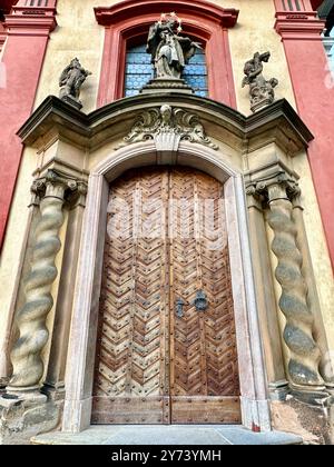 La fotografia cattura una vista dettagliata di un antico cancello medievale in legno e metallo, situato nelle strade di una storica città europea. Foto Stock