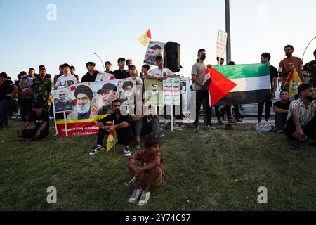 I sostenitori della fazione armata Kataeb Sayyid al-Shuhada (membro delle forze di mobilitazione popolare al-Shaabi o PMF) detengono una bandiera palestinese (R) e una bandiera (L) con ritratti del leader supremo iraniano Ayatollah Ali Khamenei (R), Abu Ala al-Walai, capo della Kataeb Sayyid al-Shuhada (2-R), Hezbollah di Mosul nella città di Mosul, Iraq. (Foto di Ismael Adnan/SOPA Foto Stock