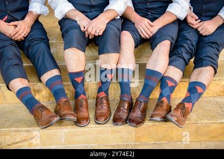 Fotografia di mani, gambe e piedi di quattro guardiani ben vestiti Foto Stock