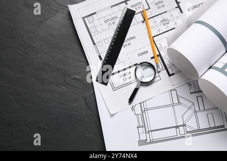 Diversi disegni architettonici, matita, righello e lente d'ingrandimento su un tavolo a trama grigia, piano. Spazio per il testo Foto Stock