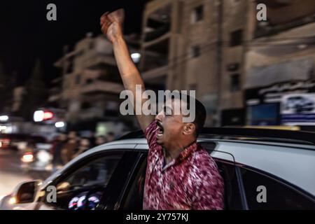 Idlib, Siria. 27 settembre 2024. I siriani celebrano nella città di Idlib dopo la notizia dell'uccisione del leader della milizia di Hezbollah, Hassan Nasrallah. L'esercito israeliano ha detto di aver attaccato il quartier generale della milizia di Hezbollah in un sobborgo di Beirut venerdì. Crediti: Anas Alkharboutli/dpa/Alamy Live News Foto Stock