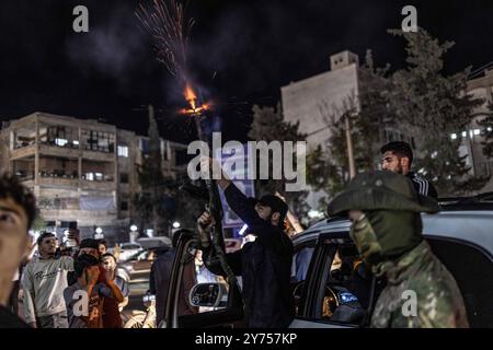 Idlib, Siria. 27 settembre 2024. I siriani celebrano nella città di Idlib dopo la notizia dell'uccisione del leader della milizia di Hezbollah, Hassan Nasrallah. L'esercito israeliano ha detto di aver attaccato il quartier generale della milizia di Hezbollah in un sobborgo di Beirut venerdì. Crediti: Anas Alkharboutli/dpa/Alamy Live News Foto Stock