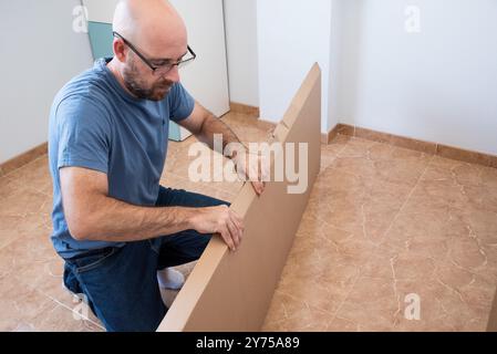 Ritratto di un uomo che assembla mobili. Fai da te il set di mobili. Foto Stock