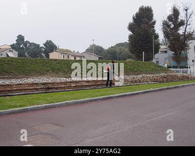 Cremona, Italia 26 settembre 2024 Un giardiniere si occupa di un parco in autunno, utilizzando un soffiatore di foglie per raccogliere le foglie cadute Foto Stock