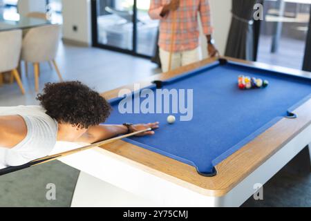 Piscina per giocare, amici diversi che si divertono insieme intorno al tavolo da biliardo, a casa Foto Stock