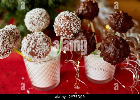 Ciambelle al cioccolato assortite decorate con noce di cocco in bicchiere durante un evento festivo Foto Stock