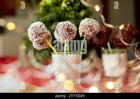 Ciambelle al cioccolato assortite decorate con noce di cocco in bicchiere durante un evento festivo Foto Stock