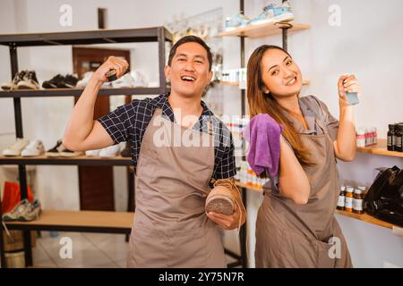 lavoratori asiatici in piedi con attrezzi per la pulizia delle scarpe Foto Stock