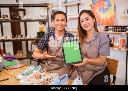 dipendenti seduti con un tablet con uno schermo di simulazione Foto Stock