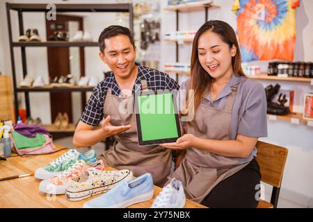 lavoratori asiatici seduti tenendo un tablet con uno schermo per il mockup Foto Stock