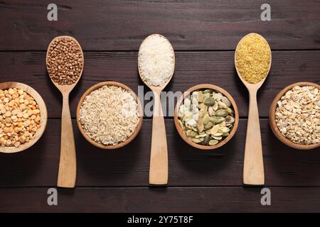 Diversi tipi di cereali e semi su tavola di legno, piatti Foto Stock