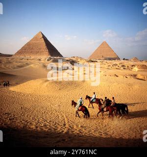 Touristengruppen bei einem Ausritt zwischen den Pyramiden des Chephren (Links) und des Cheops auf dem Pyramidenplateau in Gizeh, Ägypten um 1987. Foto Stock