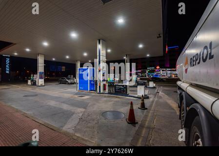 Autocisterna dell'azienda Repsol che scarica in una stazione di servizio di notte, servizio di fornitura 24 ore su 24. Foto Stock