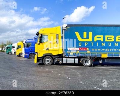 Camion parcheggiati in un parcheggio di camion presso una stazione di servizio autostradale. Foto Stock