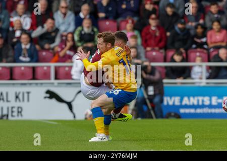 Stadio PTS Academy, Northampton, sabato 28 settembre 2024. Aaron McGowan del Northampton Town viene fregato da Stephen Quinn del Mansfield Town durante la prima metà della partita di Sky Bet League 1 tra Northampton Town e Mansfield Town al PTS Academy Stadium di Northampton, sabato 28 settembre 2024. (Foto: John Cripps | mi News) crediti: MI News & Sport /Alamy Live News Foto Stock