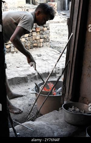 Ambatolampy, alluminio artificiale artigianale. Lavoratore con crogiolo in alluminio fuso. Altopiani centrali, regione di Vakinankaratra, Madagascar. Foto Stock