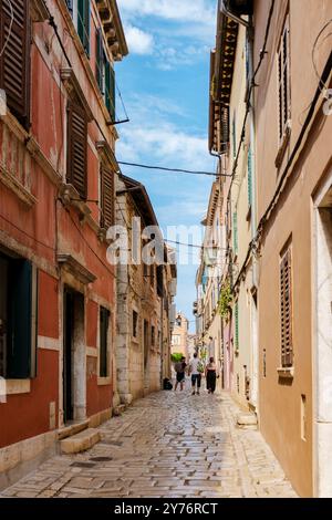 Passeggia per le pittoresche strade acciottolate di Rovigno, Croazia, dove i vivaci edifici fiancheggiano la strada e la luce del sole balla sulle facciate storiche, creando un'atmosfera perfetta da scoprire. Foto Stock