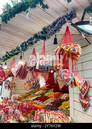 Piatti tradizionali in vendita al mercatino di Natale. Mercatino di Natale. Chiosco in legno con decorazioni natalizie e dolci Foto Stock