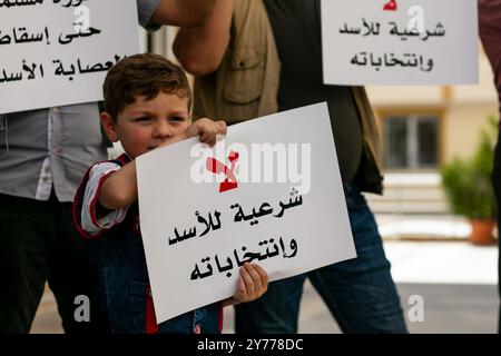 Gaziantep, Turchia. 26 maggio 2021. Decine di sostenitori dell'opposizione siriana organizzano una protesta contro le attuali elezioni presidenziali in Siria. Durante l'evento i bambini dei partecipanti hanno fatto la fila per esprimere il loro voto di dissenso in una scatola di cartone con caricature del presidente siriano. 12.000 seggi elettorali sono stati istituiti in tutta la Siria per il voto presidenziale, il secondo da quando il conflitto è iniziato nel 2011. Il Presidente al-Assad si candida contro Abdullah Salloum Abdullah, ex ministro di Stato per gli affari parlamentari, e Mahmoud Ahmad Marei, capo della parte del fronte Nazionale Democratico Foto Stock