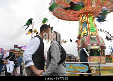 Monaco, Germania. 28 settembre 2024. Mona e Marco si baciano di fronte alla giostra della catena all'Oktoberfest. La 189esima Oktoberfest si svolgerà dal 21 settembre al 6 ottobre 2024 sul Theresienwiese di Monaco. Crediti: Felix Hörhager/dpa/Alamy Live News Foto Stock