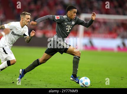 MONACO DI BAVIERA, GERMANIA - SETTEMBRE 28: Jamal Musiala del Bayern Muenchen vies con Alejandro Grimaldo del Bayer Leverkusen durante la partita di Bundesliga tra il Bayern München e il Bayer 04 Leverkusen all'Allianz Arena il 28 settembre 2024 a Monaco di Baviera, Germania. © diebilderwelt / Alamy Live News Foto Stock