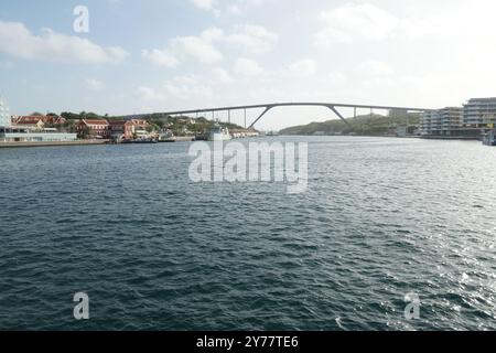 Il Queen Juliana Bridge si estende lungo il corso d'acqua, collegando Punda con l'ormeggio di Otrobanda a Willemstad, che è la capitale di Curacao. Foto Stock