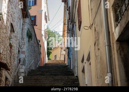 Una delle tante stradine strette di pola, in croazia, piena di alte scale che conducono alla città alta e alla fortezza Foto Stock