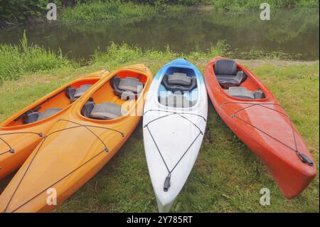 Quattro kayak sulla riva del fiume, kayak sportivi sulla riva dello stagno Foto Stock