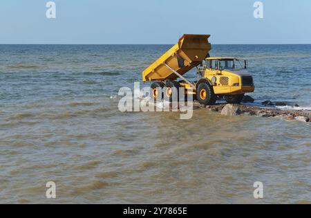 Attrezzature da costruzione a terra, costruzione di frangiflutti, misure di protezione costiere Foto Stock