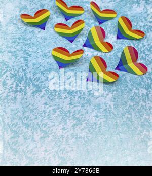 Cuore di carta di colore LGBT. Un cuore fatto di carta su sfondo blu. Il cuore è di colore arcobaleno. Un simbolo della comunità gay Foto Stock